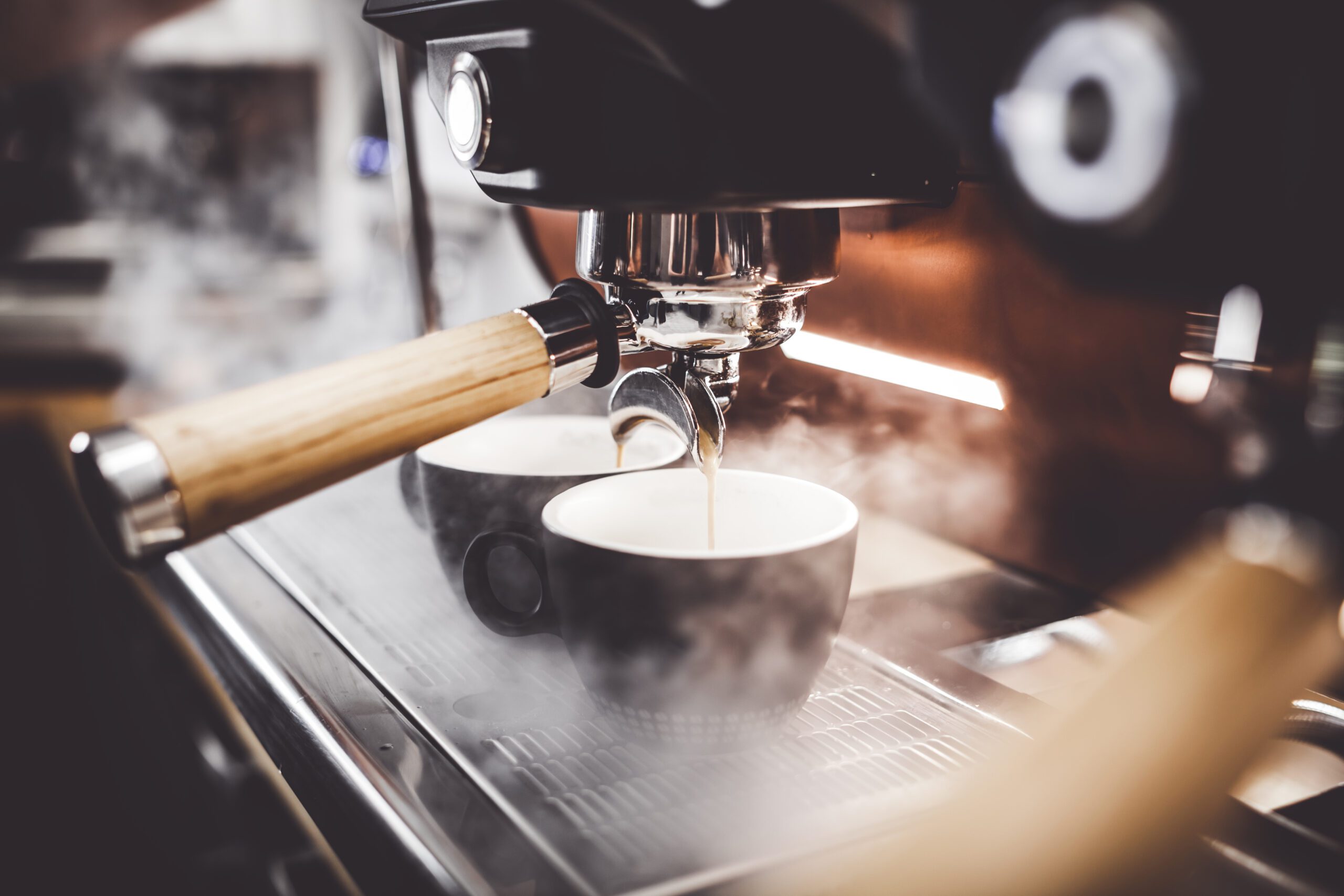 Espresso poruing from coffee machine at cafe